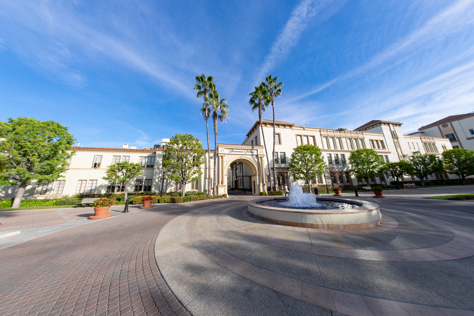 Scenic courtyard of Paramount Studios with a fountain and palm trees under a blue sky.