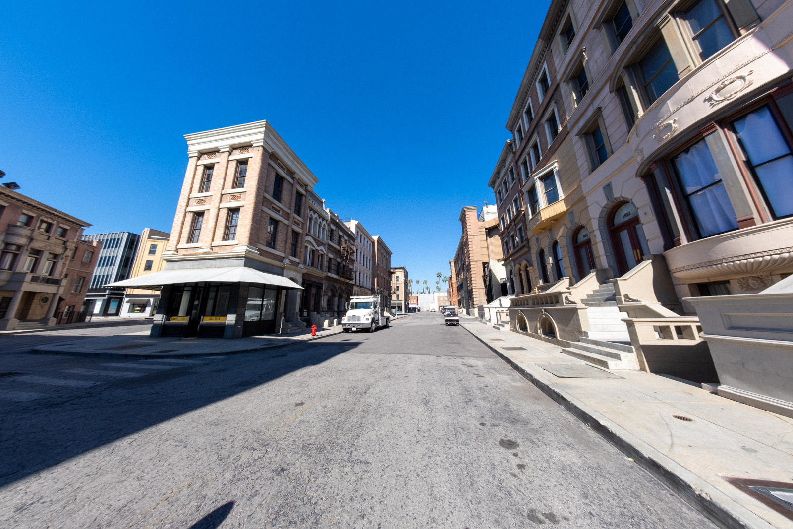 Wide shot of a quiet street featuring historic buildings under a clear blue sky.