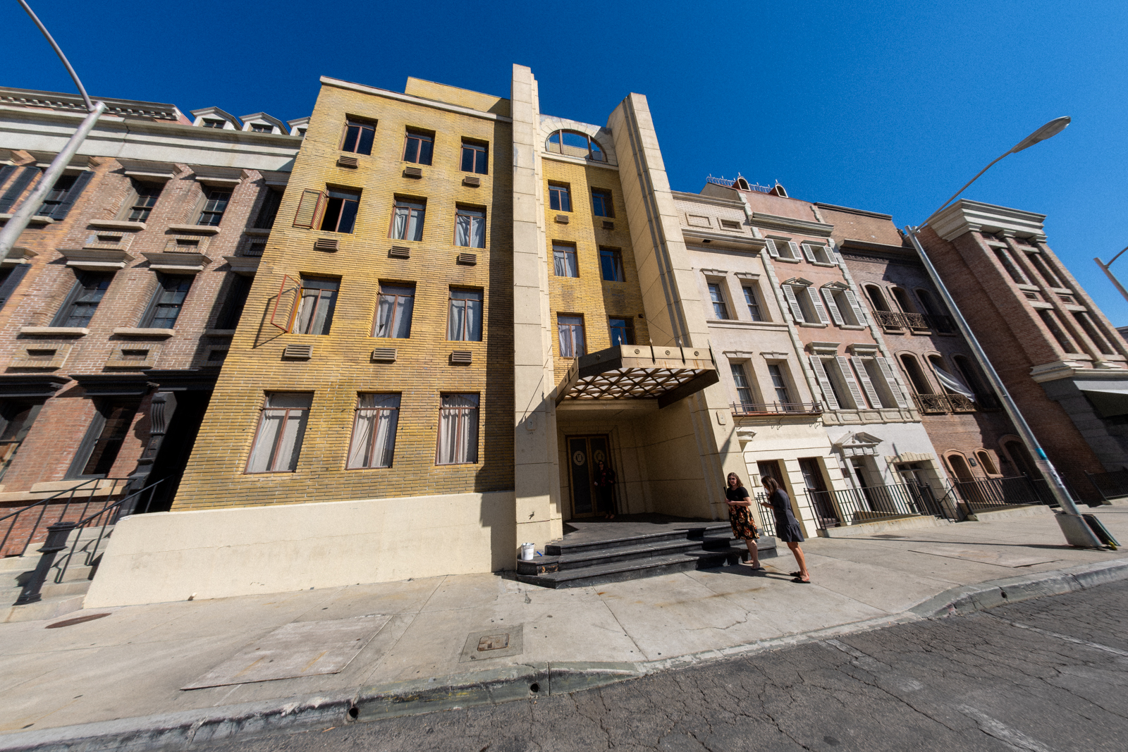 Vibrant cityscape featuring unique architectural styles of neighboring buildings under a clear blue sky.