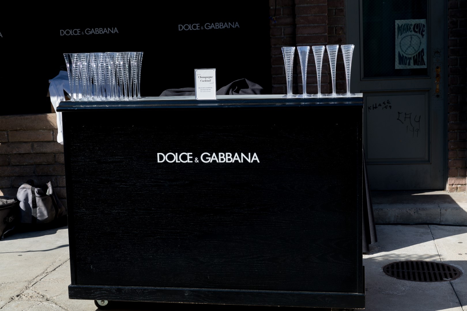 Bar with Dolce & Gabbana branding featuring champagne glasses and a cocktail sign.