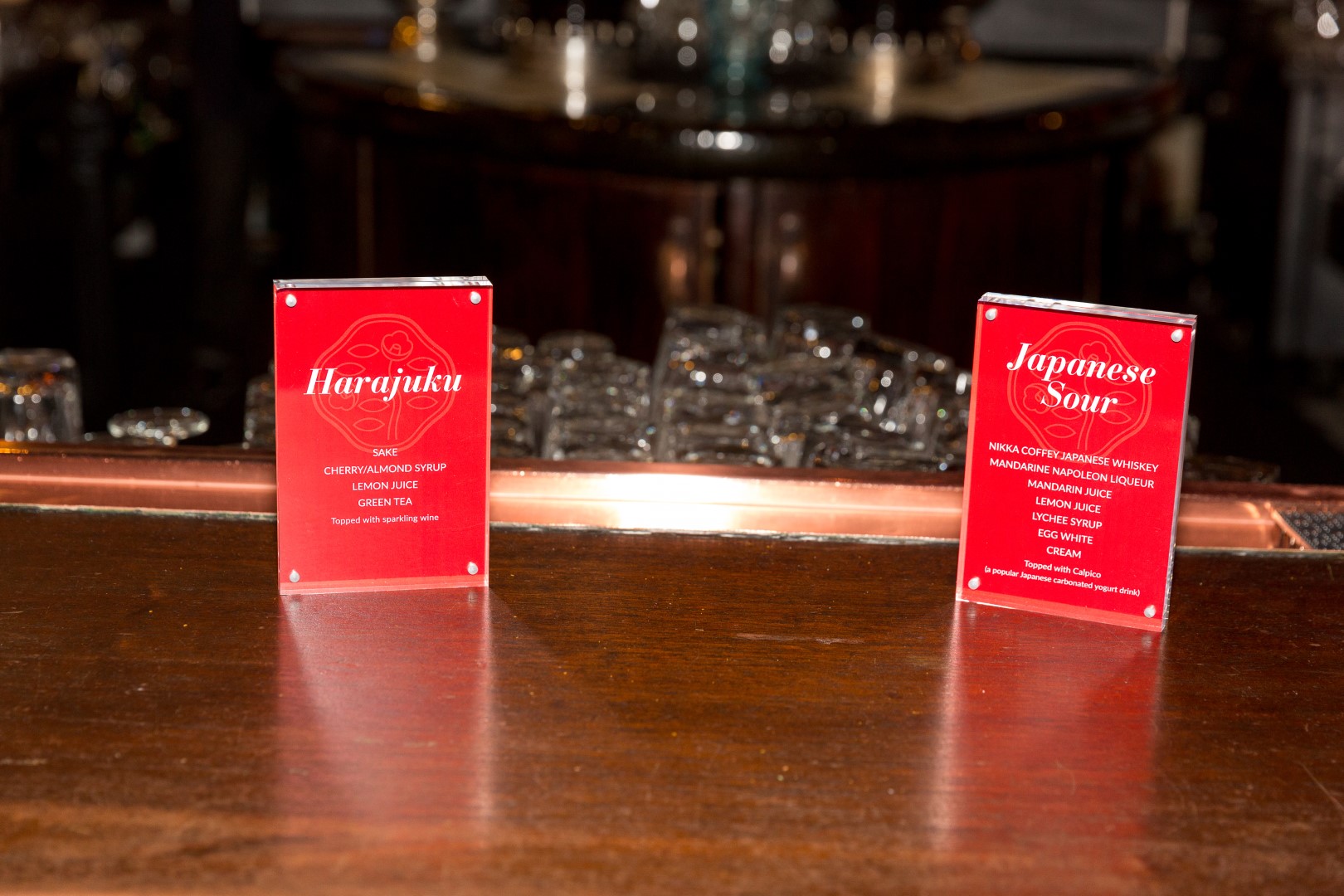 Cocktail menu featuring Harajuku and Japanese Sour drinks on a bar counter