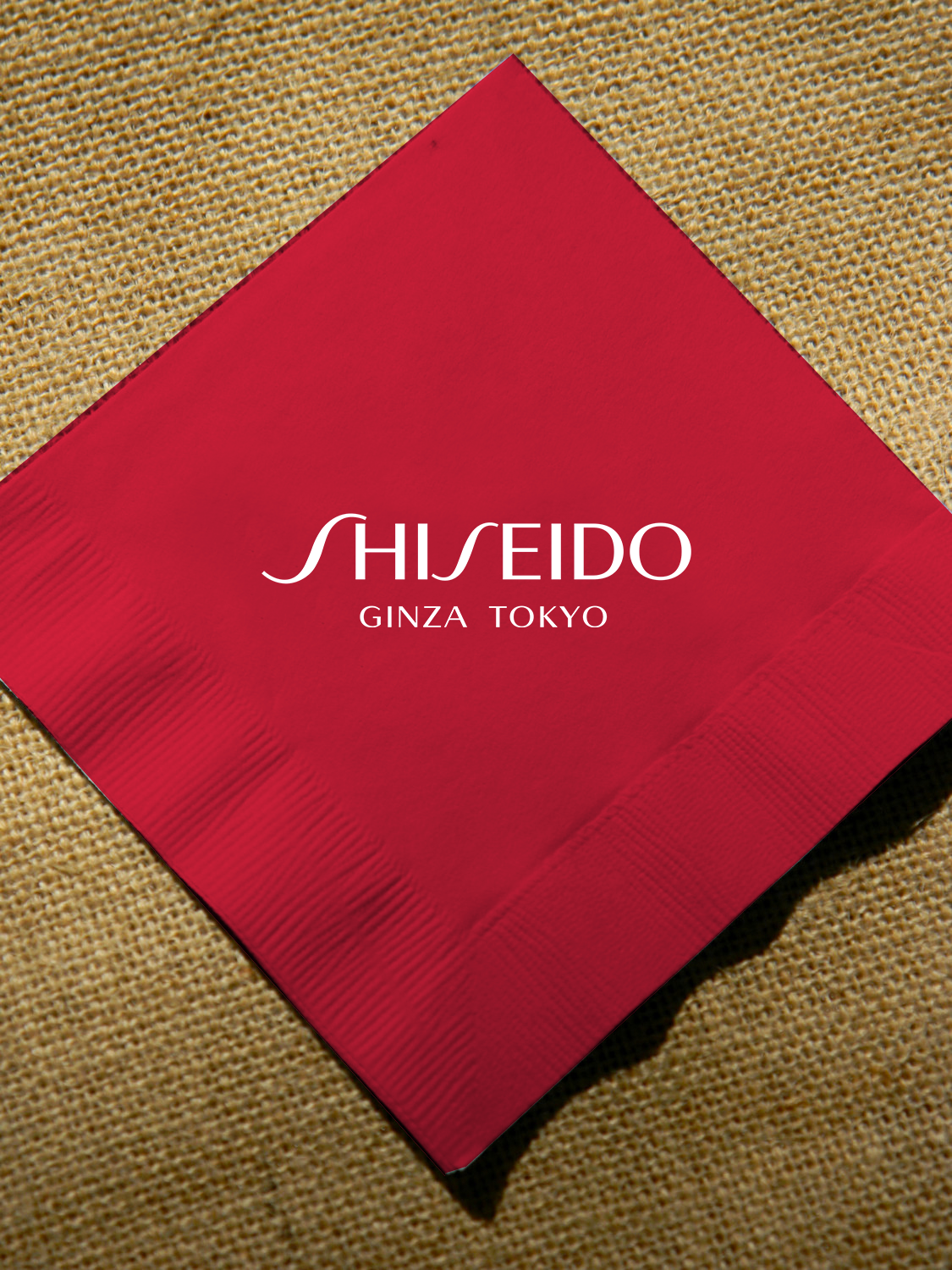 Red napkin with Shiseido logo, symbolizing luxury beauty products from Ginza, Tokyo.