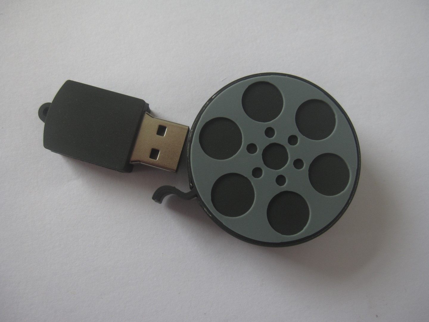 USB flash drive shaped like a film reel, ideal for storing and transferring video files.