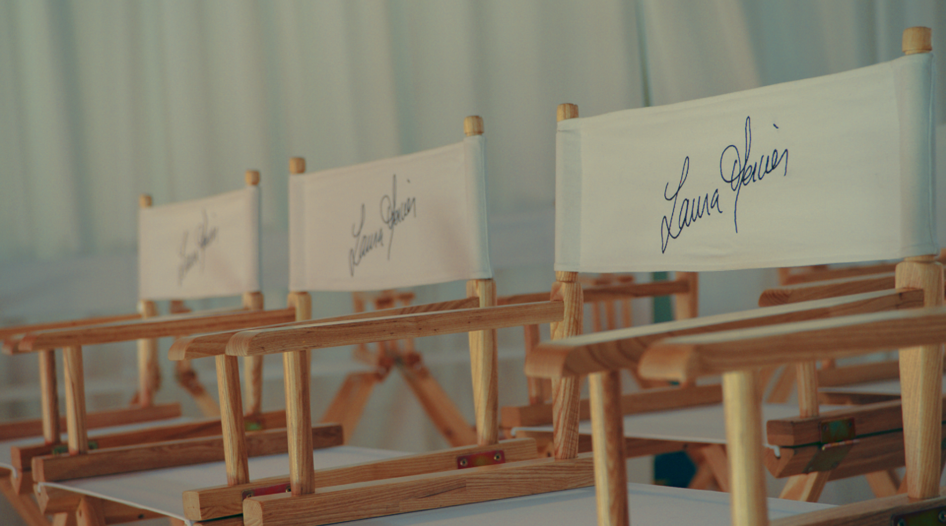 Row of director chairs with signatures, set up for a film production on location.