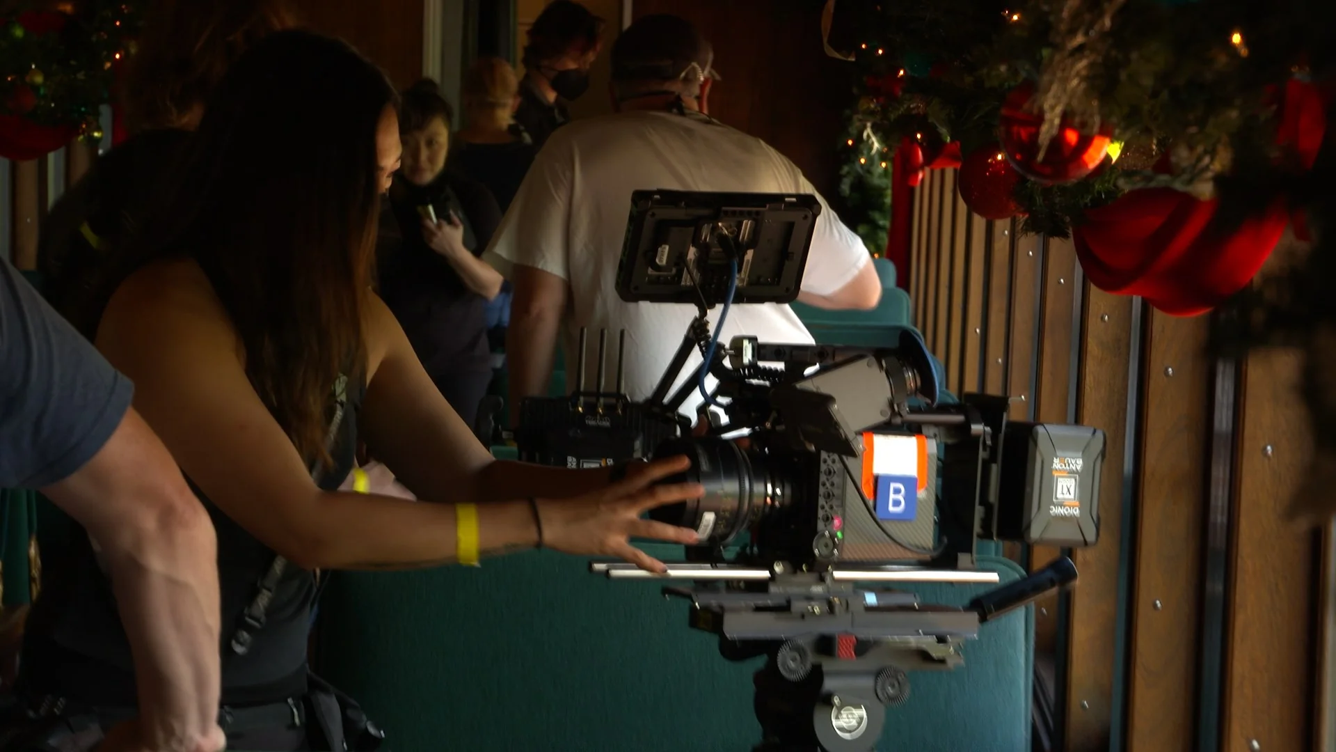 Film crew setting up a camera for a shoot in a decorated location.