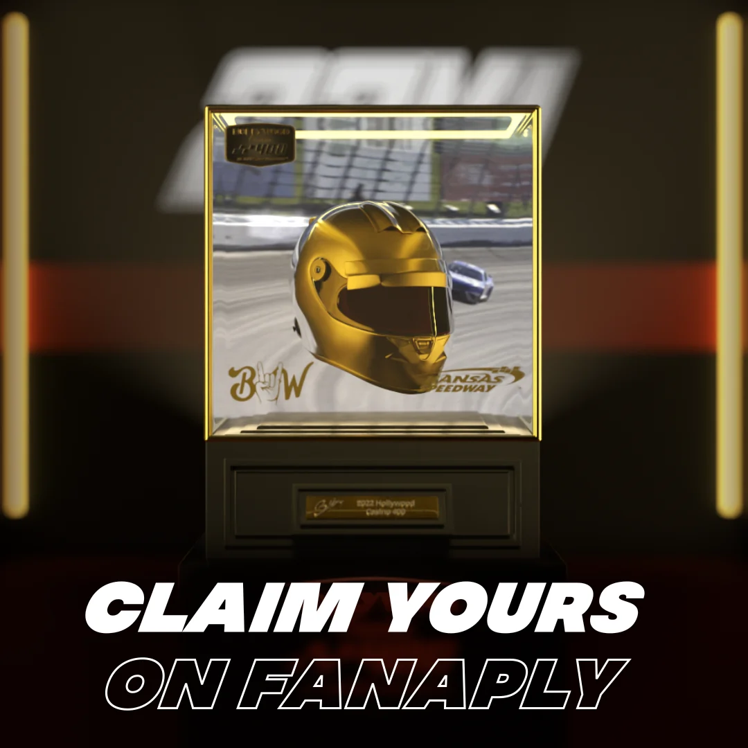 Gold racing helmet displayed in a protective case on a stand.