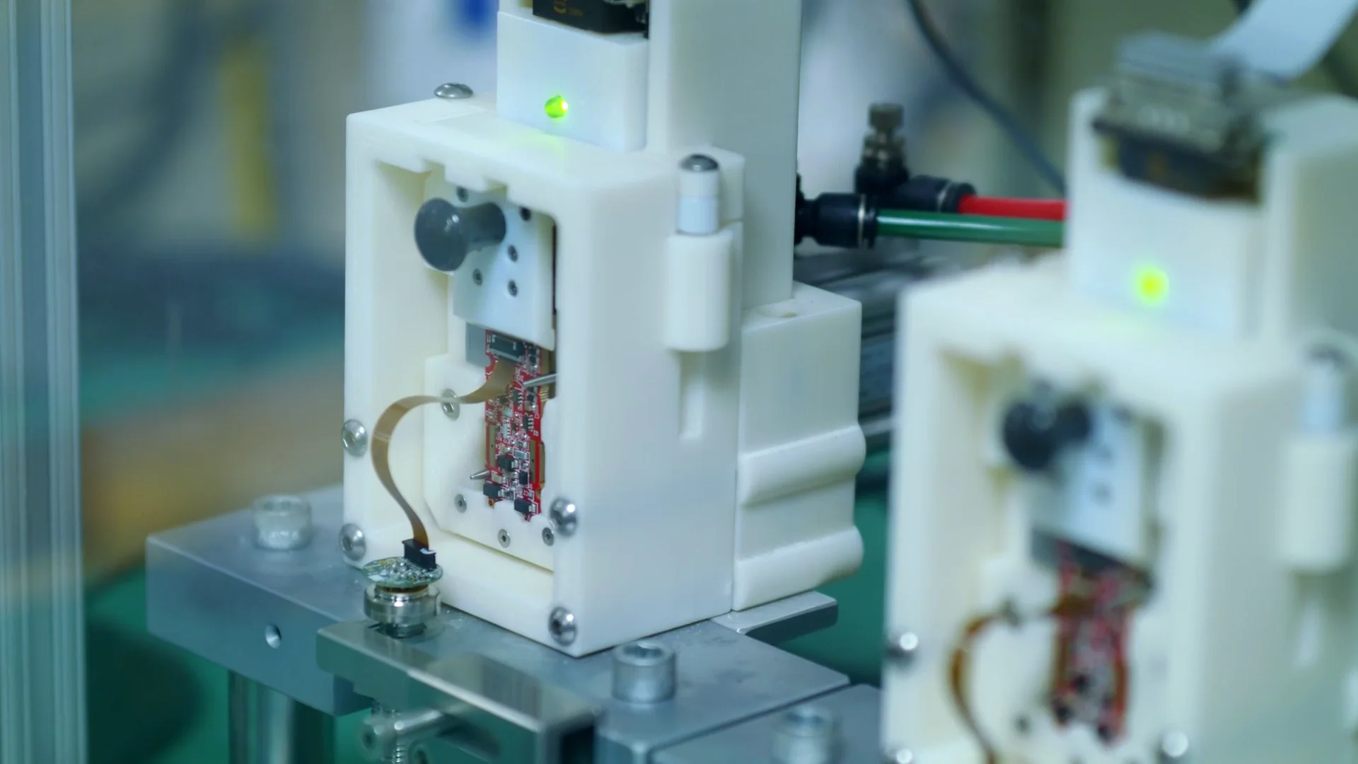 Close-up of a white electronic device with internal components and a green LED light.