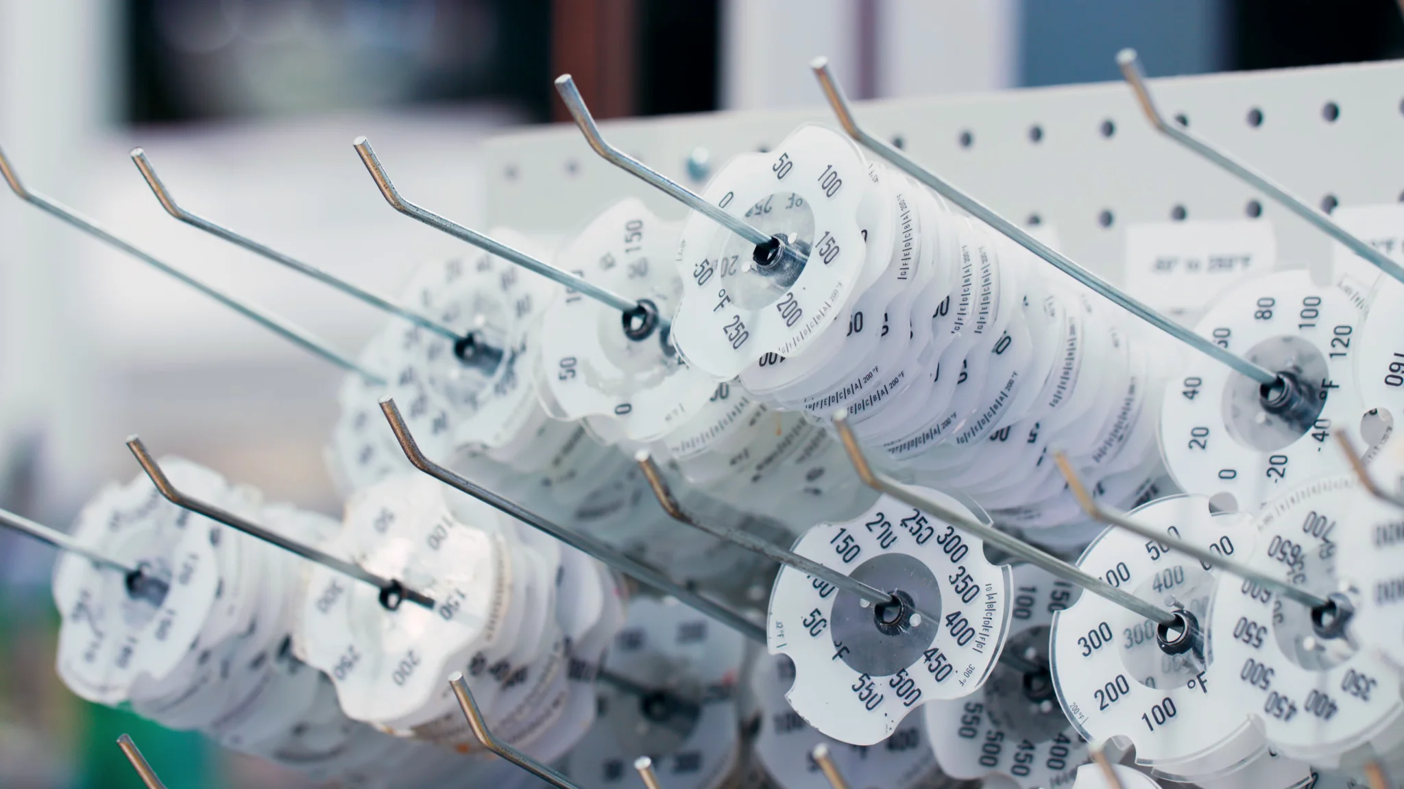 Close-up of organized measurement discs on hooks, showcasing various numerical values for calibration.