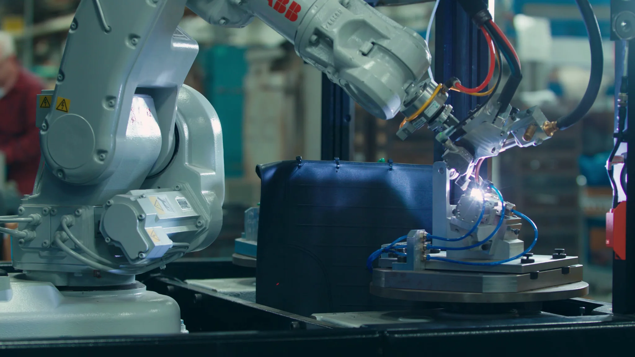 Robotic arm welding components in an industrial setting, showcasing advanced automation technology.
