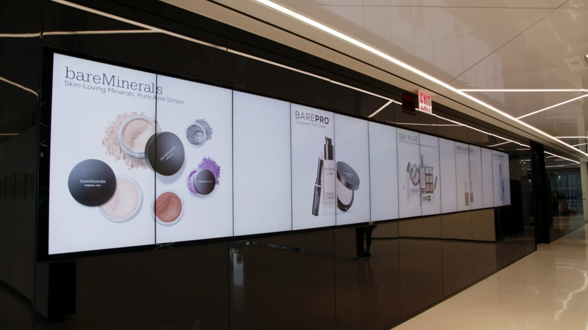 Display of bareMinerals skincare and makeup products on a wall.
