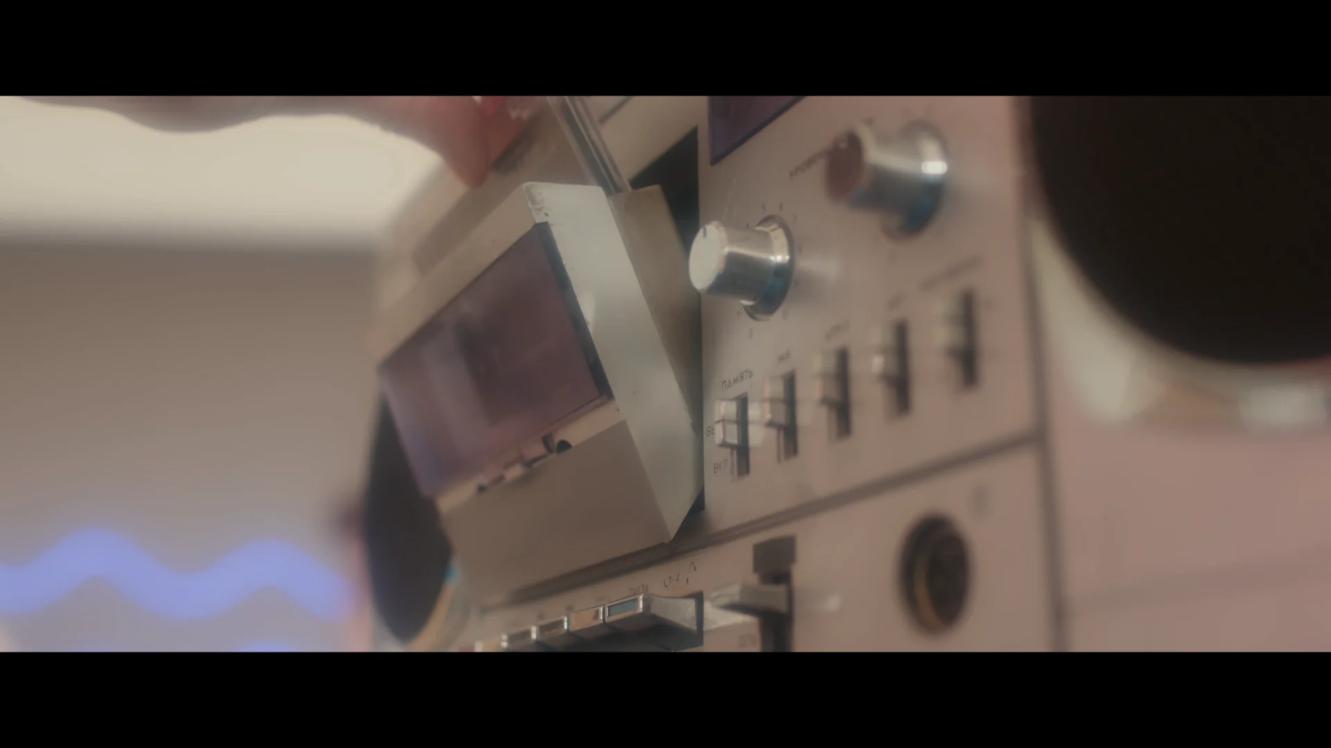 Close-up of a vintage cassette player with a hand inserting a cassette tape.